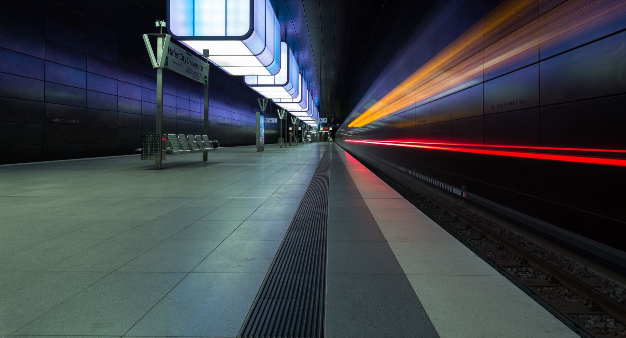 Moderne Hamburger U-Bahn-Station HafenCity Universität bei Nacht, mit Lichtspuren. Steht für die Zuverlässigkeit der PENSIONSKASSE der Hamburger Hochbahn Aktiengesellschaft -VVaG-.