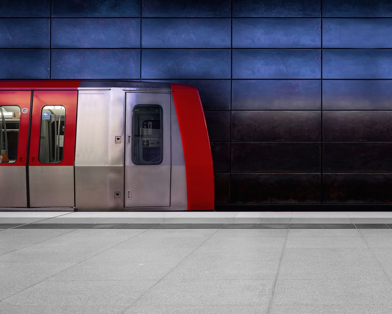 Die Front eines roten Hamburger U-Bahn-Waggons am Bahnsteig. Das Bild steht für Mobilität und Sicherheit, ebenso wie die **PENSIONSKASSE der Hamburger Hochbahn Aktiengesellschaft -VVaG-**.
